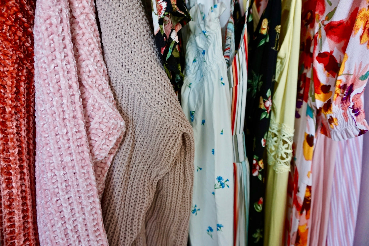 pink knit sweater beside white and blue floral dress