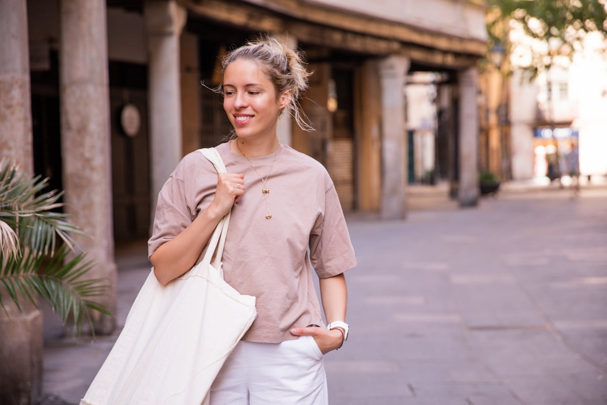 a woman carrying a white bag on a city street
